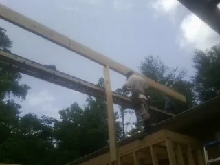 Carpenter setting a ridge beam over a new addition frame — Ice Dam Removal by Roofing Brothers in Hunlock Creek