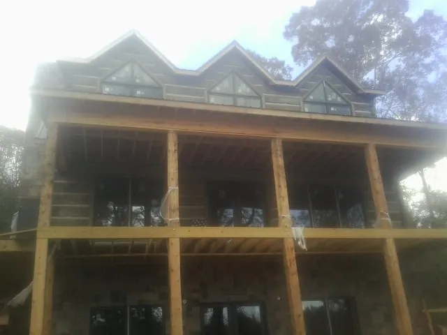 Dormers and porch framing on a large log home under construction — Roof Coating work by our crew in Hunlock Creek
